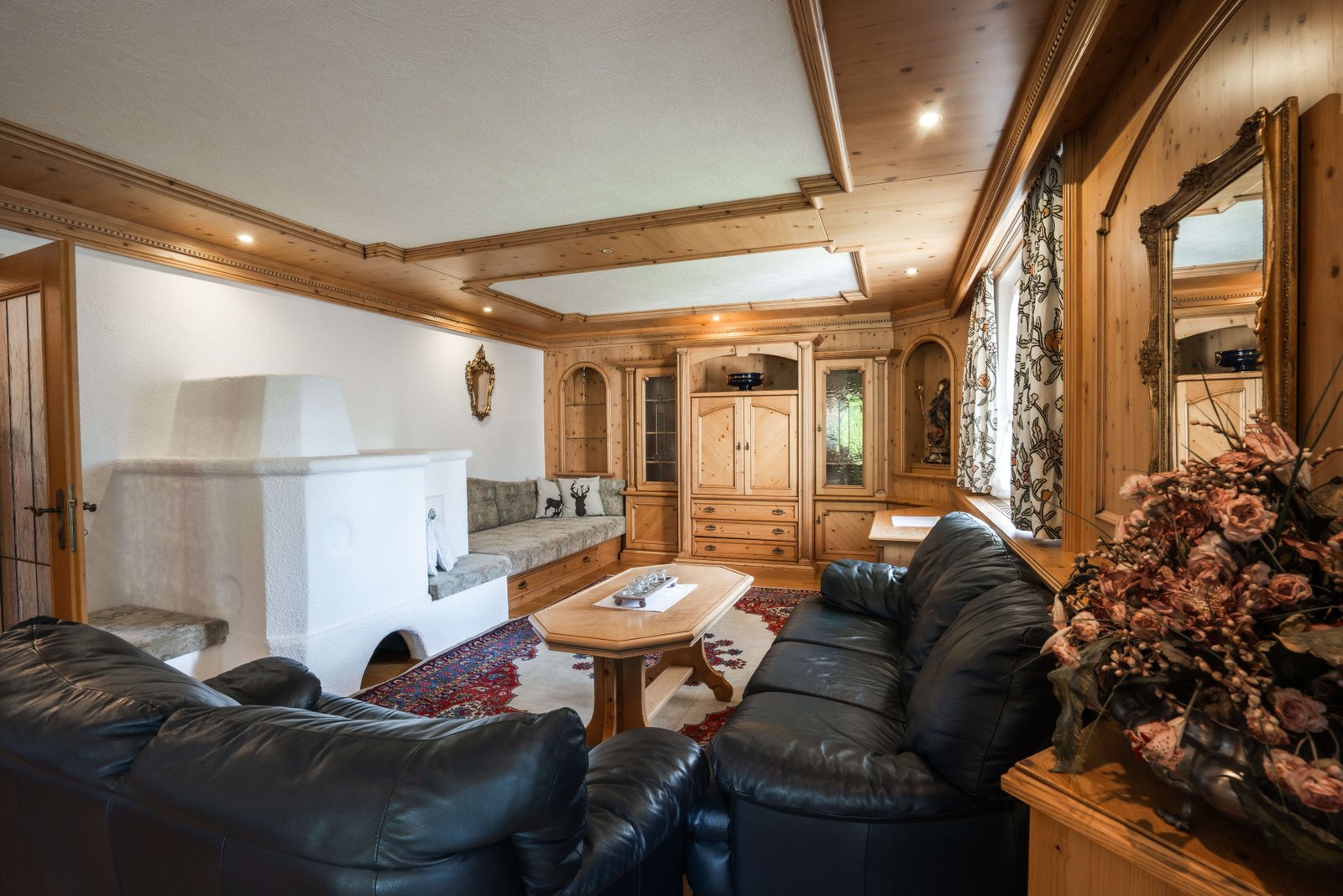 Großes Wohnzimmer mit Ledersofas und Kachelofen